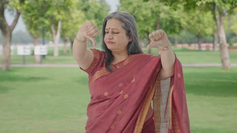 Disappointed-Indian-old-woman-showing-thumbs-down-in-park