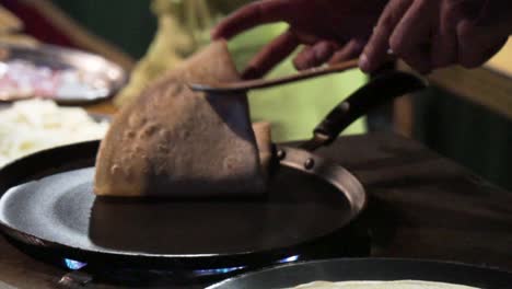 Close-shot-of-a-pancake-in-a-pan-being-folded-in-a-street-market