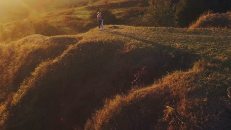 romantic young couple silhouette. aerial shot of a adorable young couple embracing and kissing tenderly in countryside at sunset