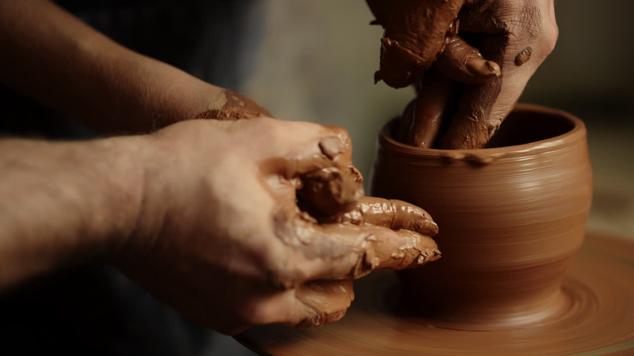 남자 와 여자 의 손 이 도자기 에서 점토 비 를 만들고 있다