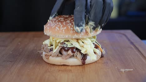 El-Chef-Coloca-Un-Bollo-De-Pan-En-Una-Hamburguesa-Recién-Preparada-De-Carne-De-Cerdo-Y-Ensalada-De-Col