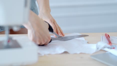 woman cutting fabric with scissors for sewing project