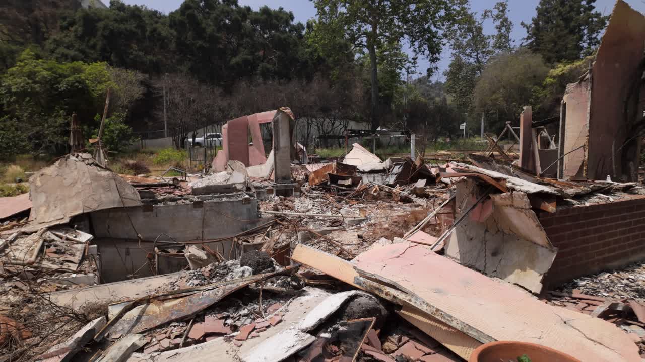 Gimbal close-up panning shot of a burned property destroyed by the Palisades Fire in Los Angeles, California. 4K