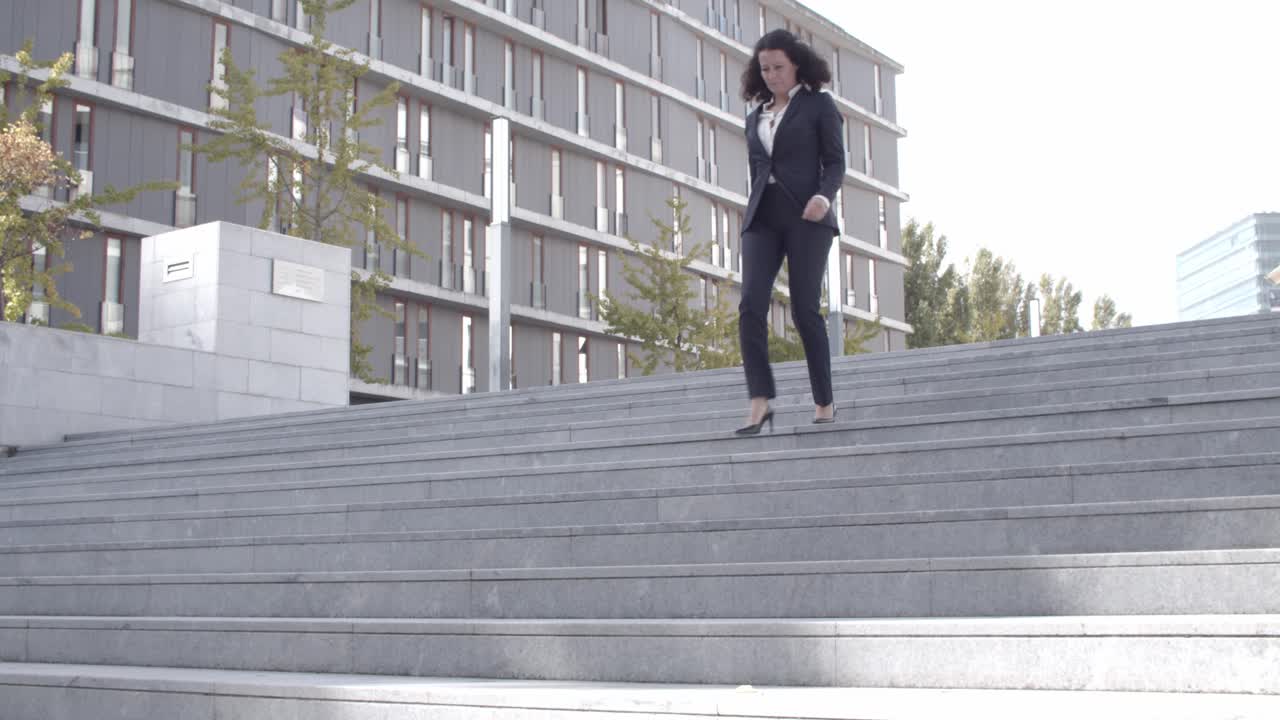 아래층으로 내려가는 직업적인 곱슬머리 사업가