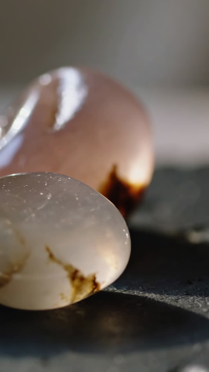 Vertical video: Moving camera sliding right over slate, showing polished stones' texture and glow
