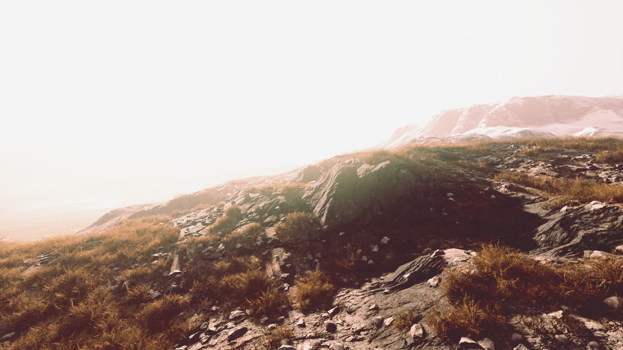 hermosa vista panorámica del atardecer en la cordillera y la hierba amarilla seca en el frente