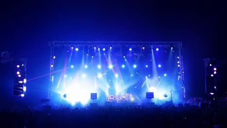 un escenario de concierto con una gran multitud de personas viendo la actuación