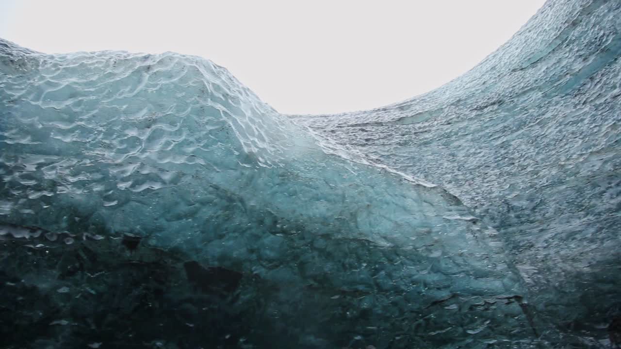 Vista mozzafiato di una grotta di ghiaccio con acqua che gocciola sulla telecamera.