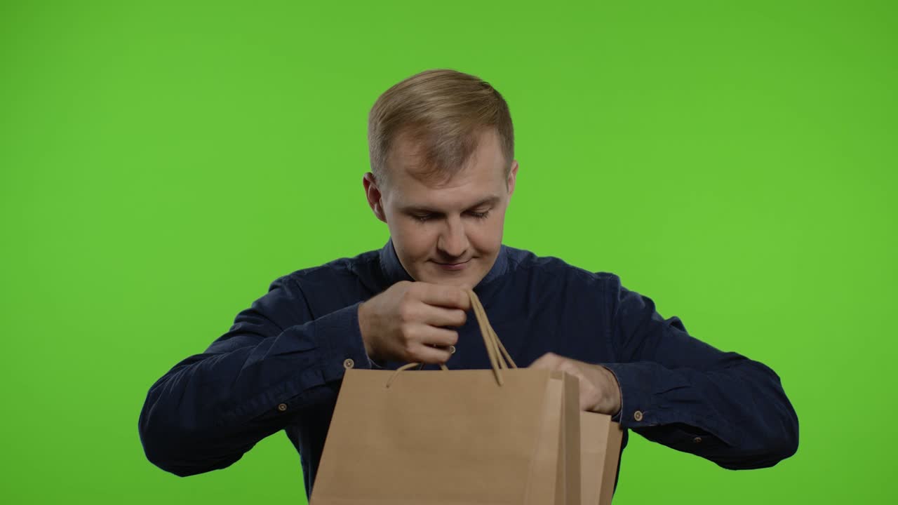 저렴한 가격에 만족한 미소 짓는 쇼핑 가방에서 할인 할인 문구를 꺼내는 사람