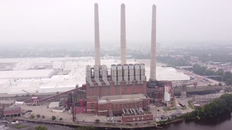 the otto eckert power station facing grand river at misty morning in lansing michigan, usa