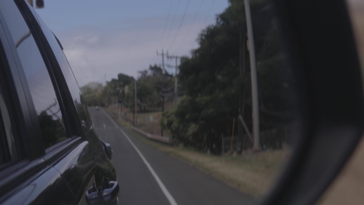 뒷 거울 을 바라보면서 도로 를 운전 하는 것