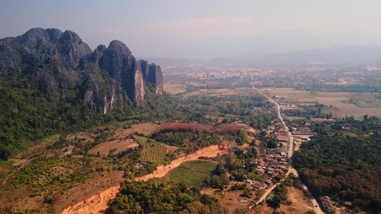Aerial View of a Laotian Valley with Mountains and Rural Village