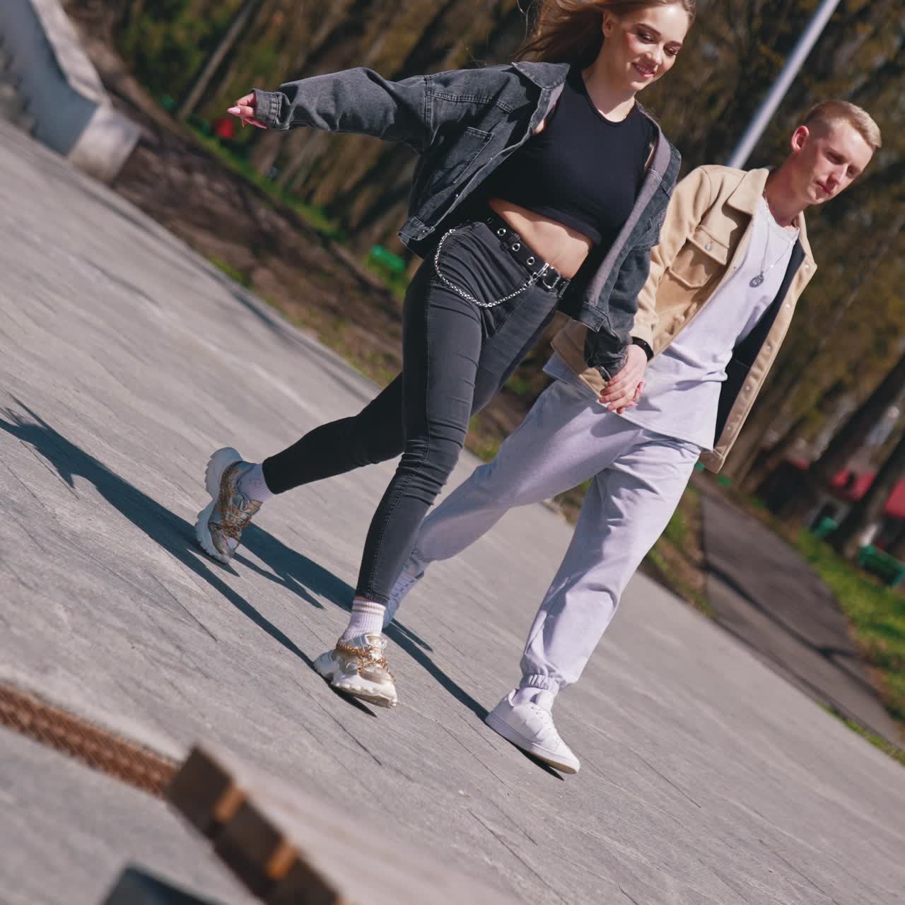 Happy couple sitting at the bench at the park. Good looking couple spending time with each other in the street in a sunny day. Young people enjoying the time together concept