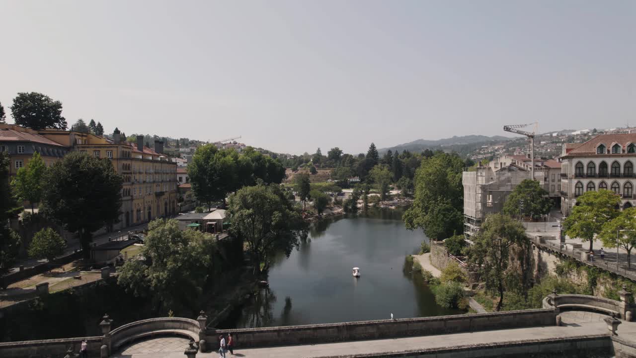 toma de dolly out sobre el río tamega sobre el puente sao goncalo capturando edificios históricos junto al río
