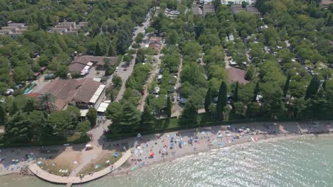 Toma-Aérea-De-La-Playa-En-El-Camping-Bella-Italia-En-El-Lago-De-Garda,-Italia