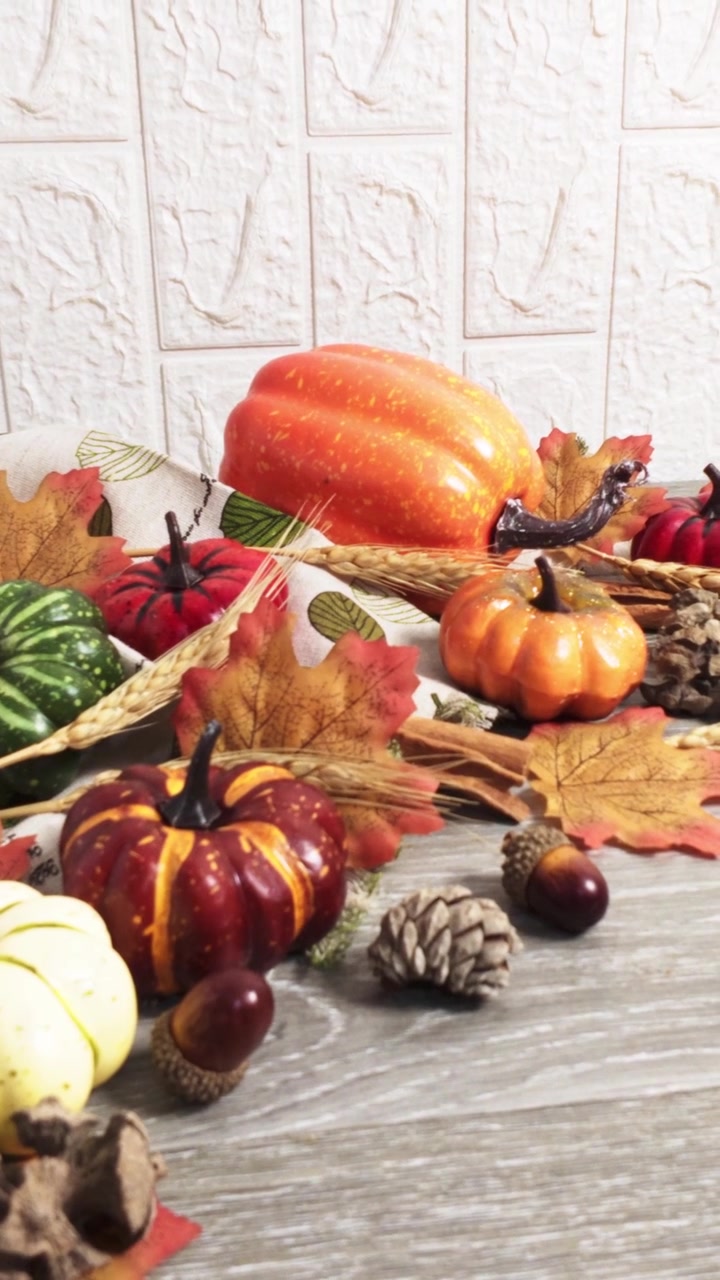 Zucche decorative autunnali e fogliame autunnale su un tavolo di legno.