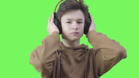 retrato de un niño caucásico triste escuchando música clásica tranquila en auriculares. primer plano de una adolescente morena con ojos marrones disfrutando de la melodía en auriculas. pasatiempo, estilo de vida. fondo chromakey.