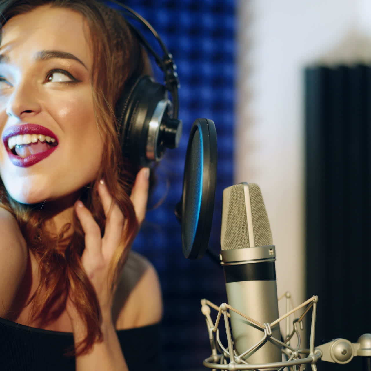 Vinnitsa, Ucraina - Maggio 2019: Giovane donna che registra una canzone in uno studio professionale. La ragazza canta nel microfono.