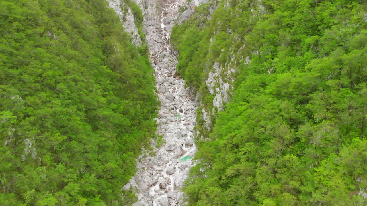 imágenes aéreas de una cascada y un río que atraviesan un cañón verde y empinado en eslovenia