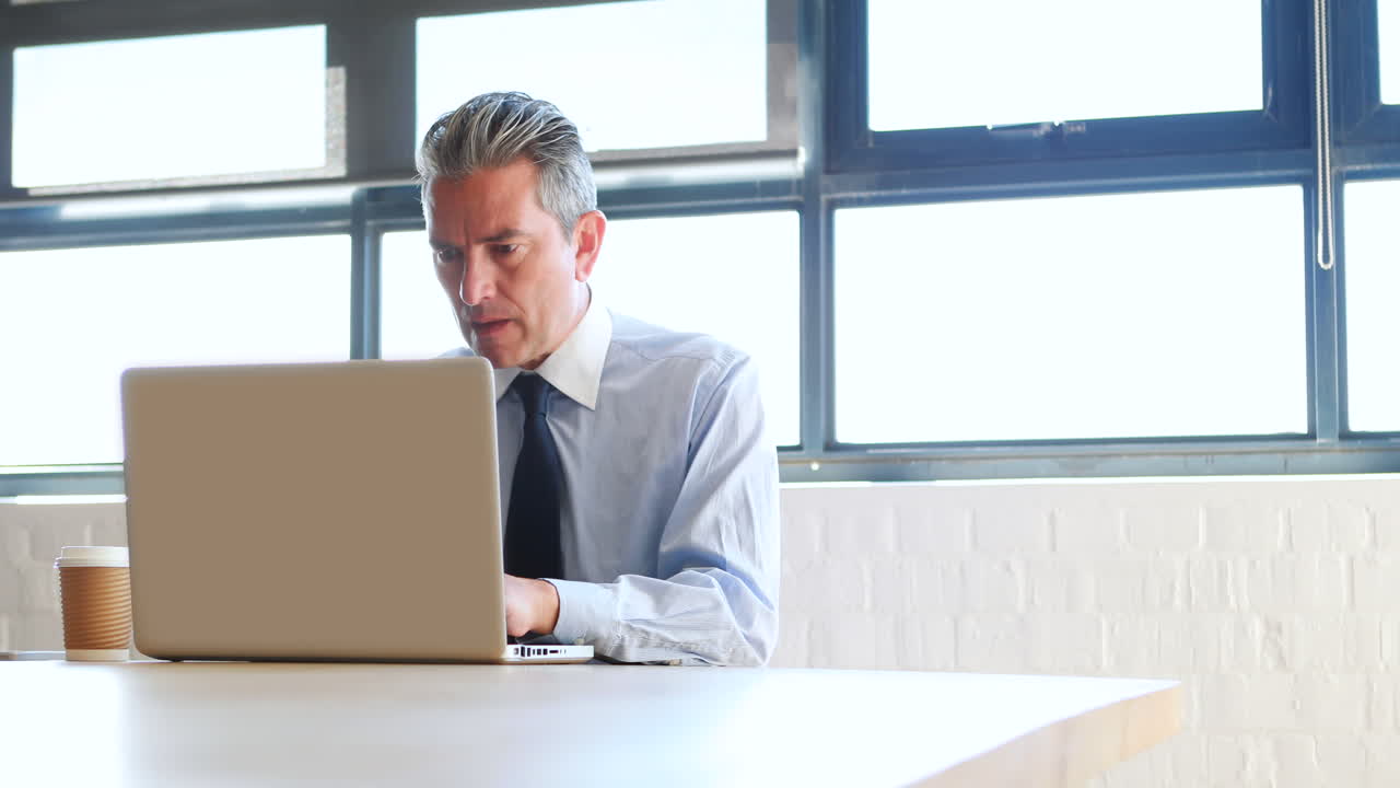 Businessman using laptop and drinking coffee