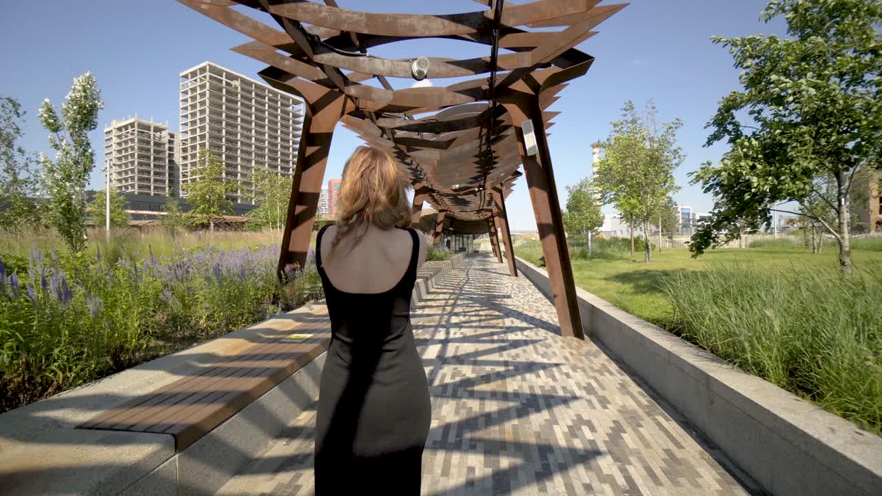 Woman in a park, taking pictures of the city