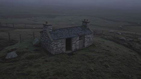foggy morning scene with small stone house and sheep