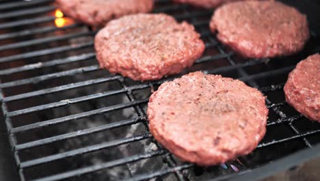 lid opening on grill and spatula flipping alternative meat burger patties on a barbecue, close up shot with flame in 60 frames per second 4k