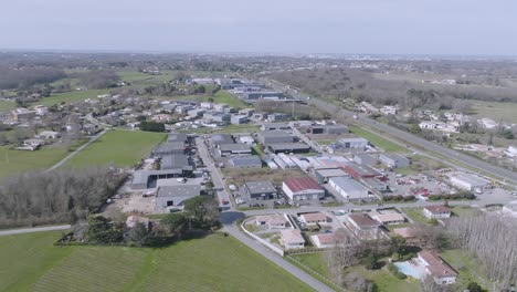 Commune-of-Montussan-France-in-the-southwestern-country-with-homes-and-agricultural-warehouses,-Aerial-dolly-out-shot