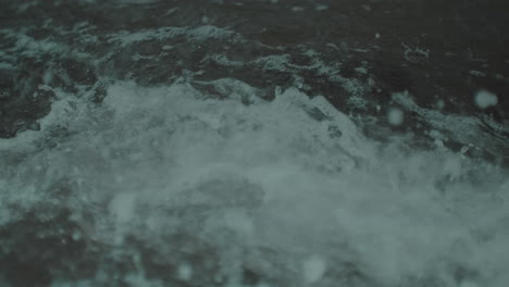 el agua gira y choca alrededor de pequeños escombros de coral rectangulares en un día de tormenta.