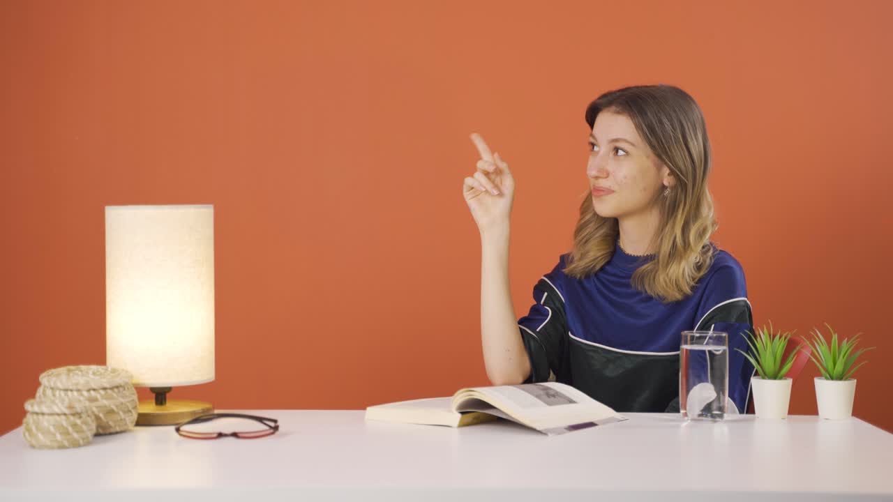 la joven que promueve está señalando hacia el lado y riendo.