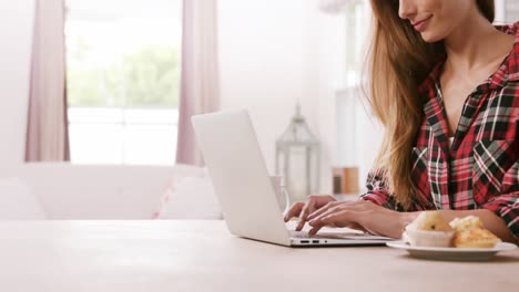 Mujer-Bonita-Usando-Laptop-Con-Muffins