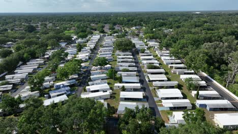 idyllic green landscape in rural area of american town with low housing area. mobile trailer homes dense in row. sunny day in valrico, florida. aerial wide shot