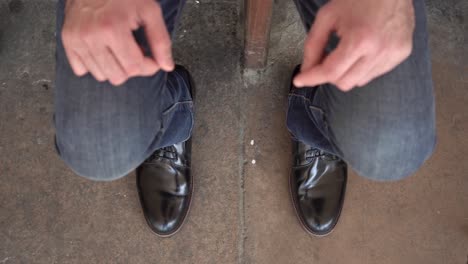 a young man is tossing the cigarette stub away with his black shoe.he is against smoking. he can't stand cigarette
