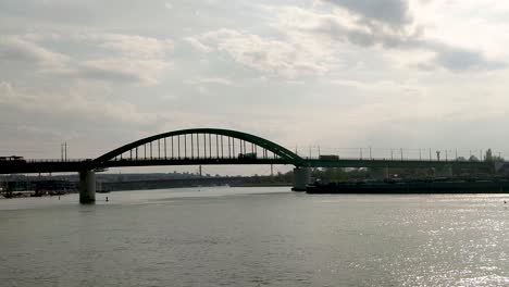 different modes of transport with train trucks barge moving on and under a bridge