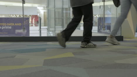 people walking by the camera inside the shopping mall part three