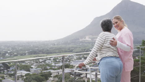 Caucasian-female-nurse-and-senior-african-american-woman-patient-with-walking-frame,-slow-motion