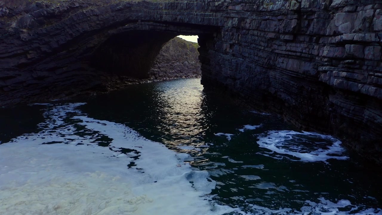 Drone hovers over sea foam at the Bridges of Ross in slow motion