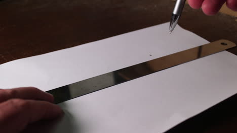 trazando dos líneas rectas en una hoja de papel y una regla de metal
