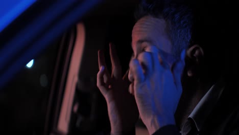 hombre de mediana edad arreglando el cabello y las cejas en el auto antes de la cita en la noche