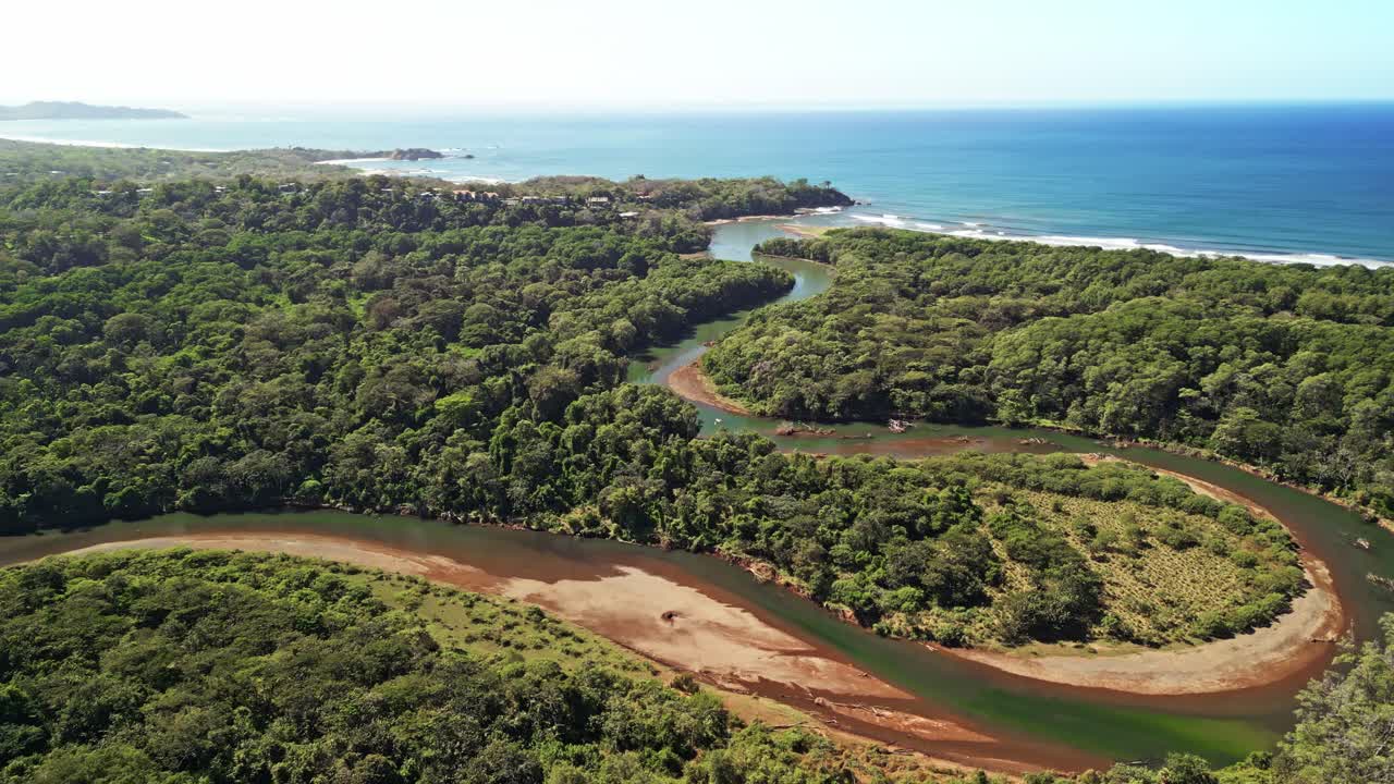 vista aérea de un río que llega al océano en nosara, costa rica