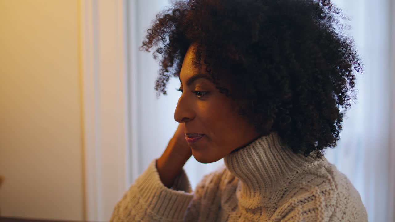 Emotional woman talking home close up. Curly hair positive lady gesturing hand