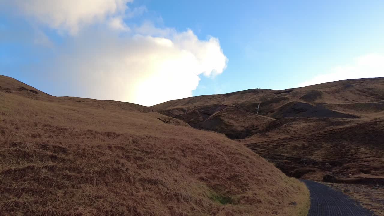 아이슬란드의 폭포 강 잔디 산 근처 길을 걷고