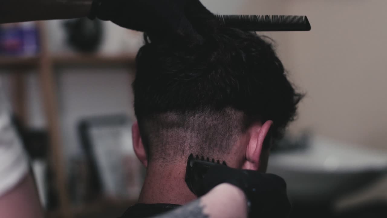 peluquero cortando el pelo de un chico usando cortaúñas