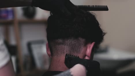peluquero cortando el pelo de un chico usando cortaúñas