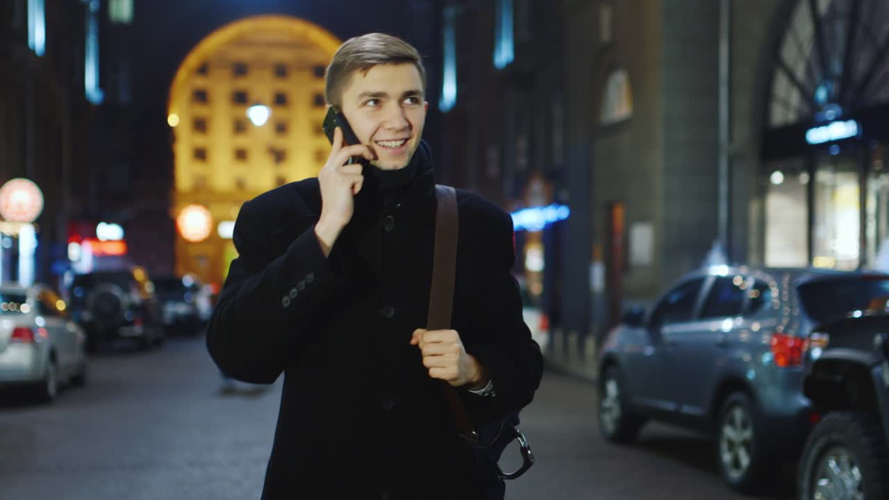 밤의 도시를 배경으로 전화 통화하는 청년 3