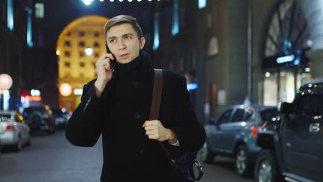 Young-man-talking-on-the-phone-against-the-backdrop-of-a-night-city-3