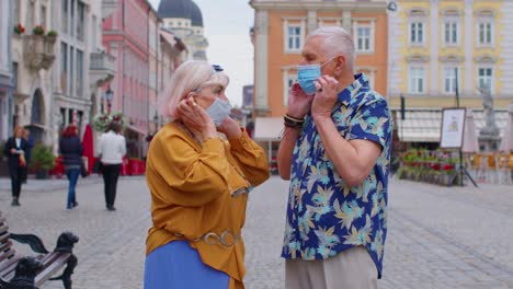 pareja de turistas mayores abuela y abuelo con máscara médica protectora contra el coronavirus
