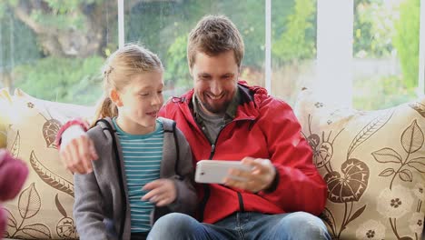 Glücklicher-Vater-Und-Tochter-Sitzen-Auf-Dem-Sofa-Und-Machen-Lustige-Gesichter,-Während-Sie-Selfie-4k-4k-Machen