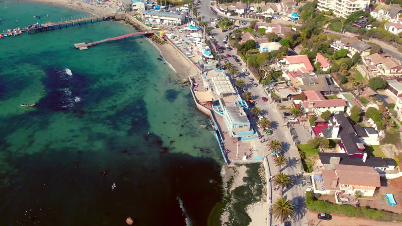 Aerial view establishing the town's fish market and the exclusive yacht club at Pejerrey beach, Chilean coastline in Algarrobo on a sunny and calm day