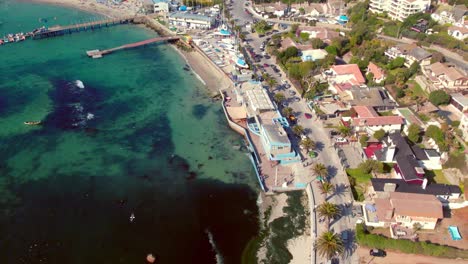 Vista-Aérea-Que-Establece-El-Mercado-De-Pescado-De-La-Ciudad-Y-El-Exclusivo-Club-De-Yates-En-La-Playa-De-Pejerrey,-Costa-Chilena-En-Algarrobo-En-Un-Día-Soleado-Y-Tranquilo